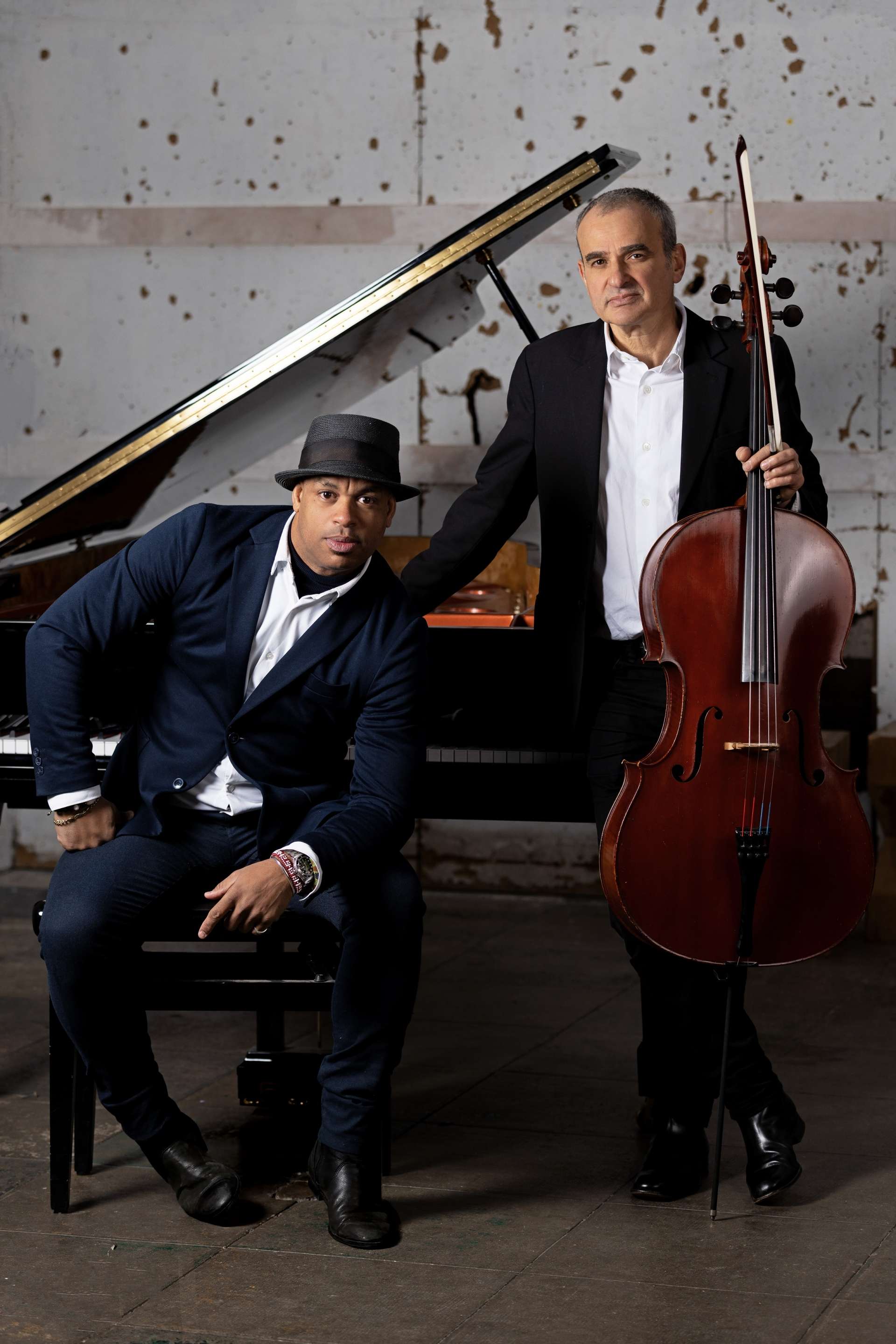 Portrait de Roberto Fonseca et Vincent Ségal devant leurs instruments : un piano et un bumcello.