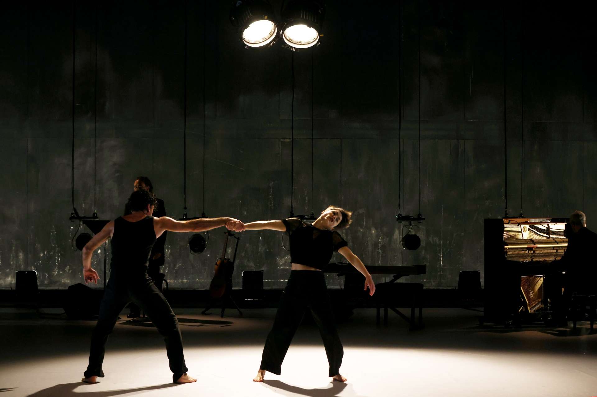 Photo du spectacle de danse Imperfecto avec deux danseurs au premier plan et des musiciens au second