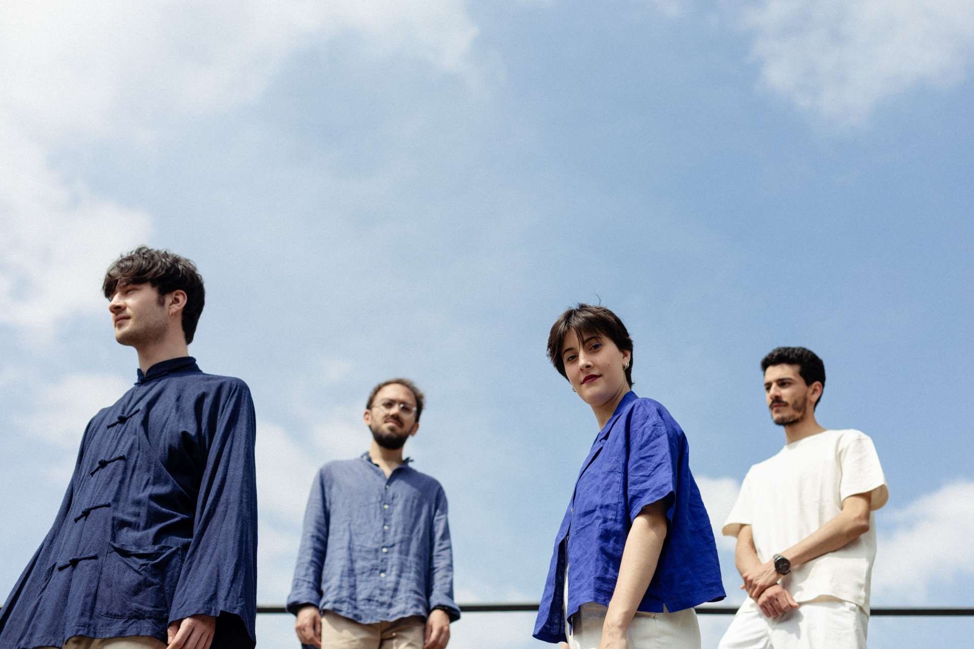 Les quatre membres du groupe Adèle Viret Quartet pose devant un magnifique ciel bleu.