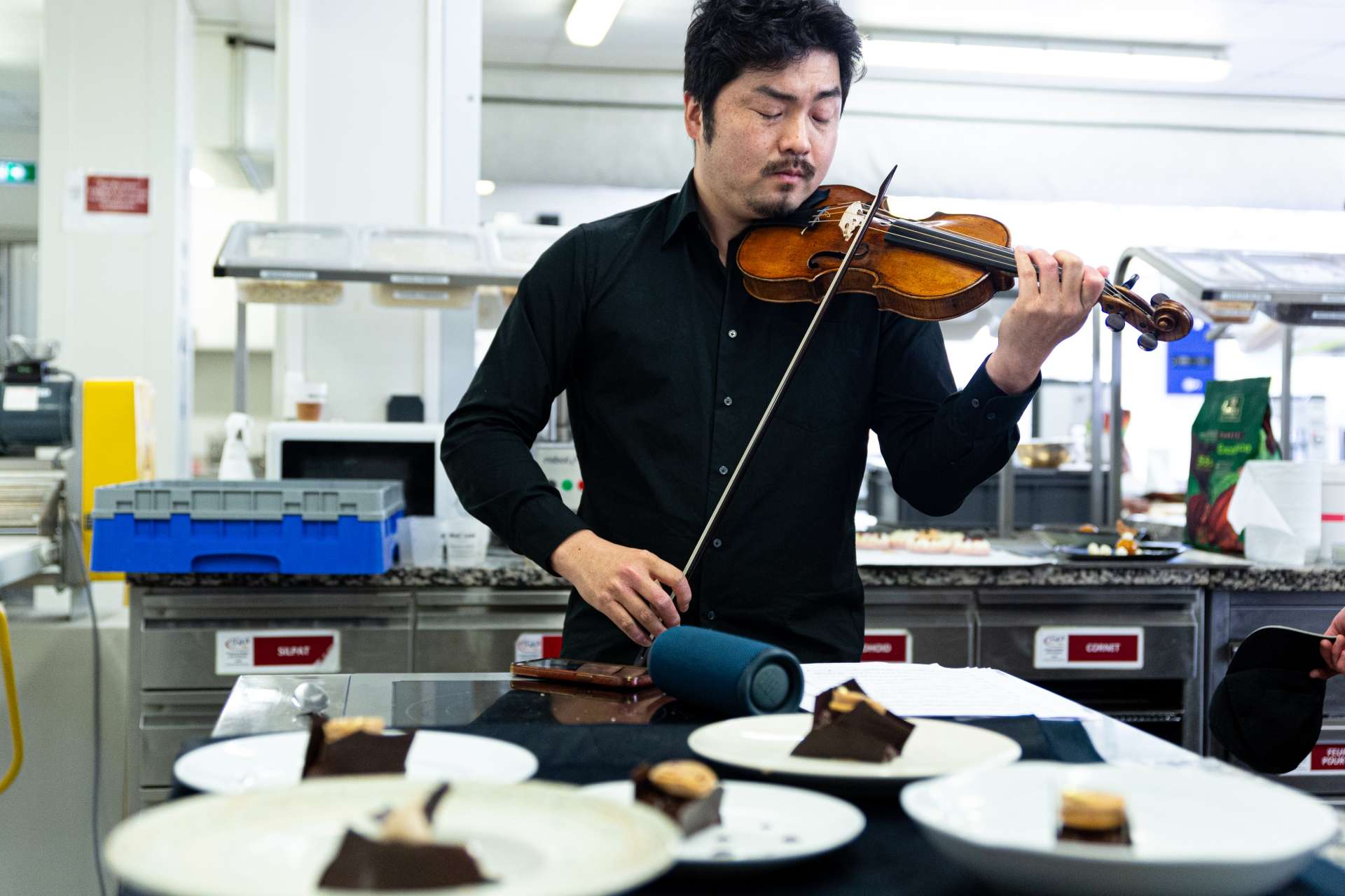 En cuisine, Koji Yoda premier violon de l'ensemble La Tempête, joue face aux pâtisseries que la musique a inspiré aux élèves de BTM Pâtisserie. 