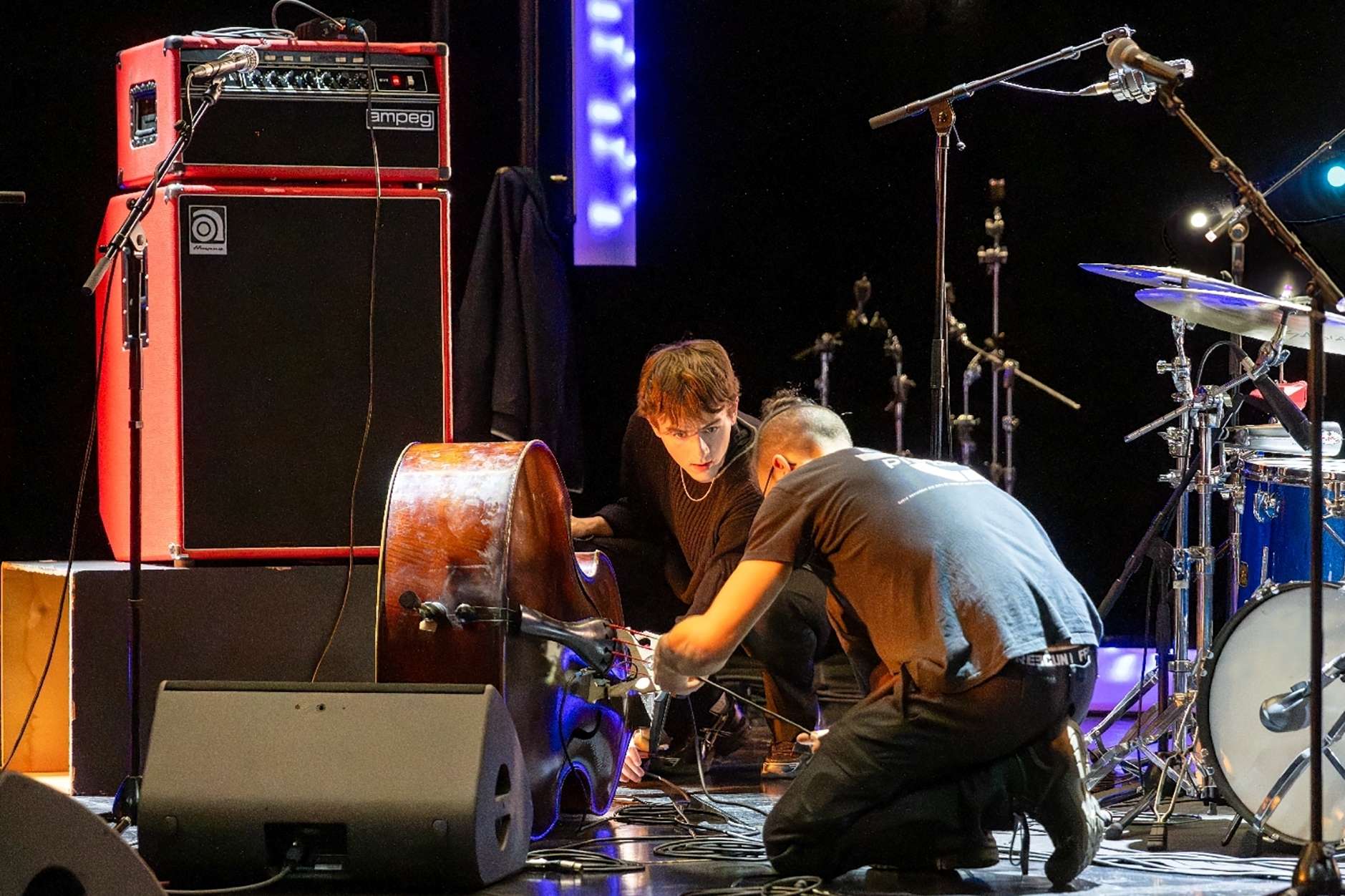 Deux techniciens installent des micros pour sonoriser un instrument.