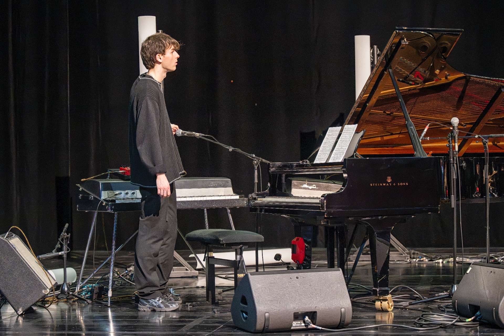 Un technicien positionne un micro devant un piano.