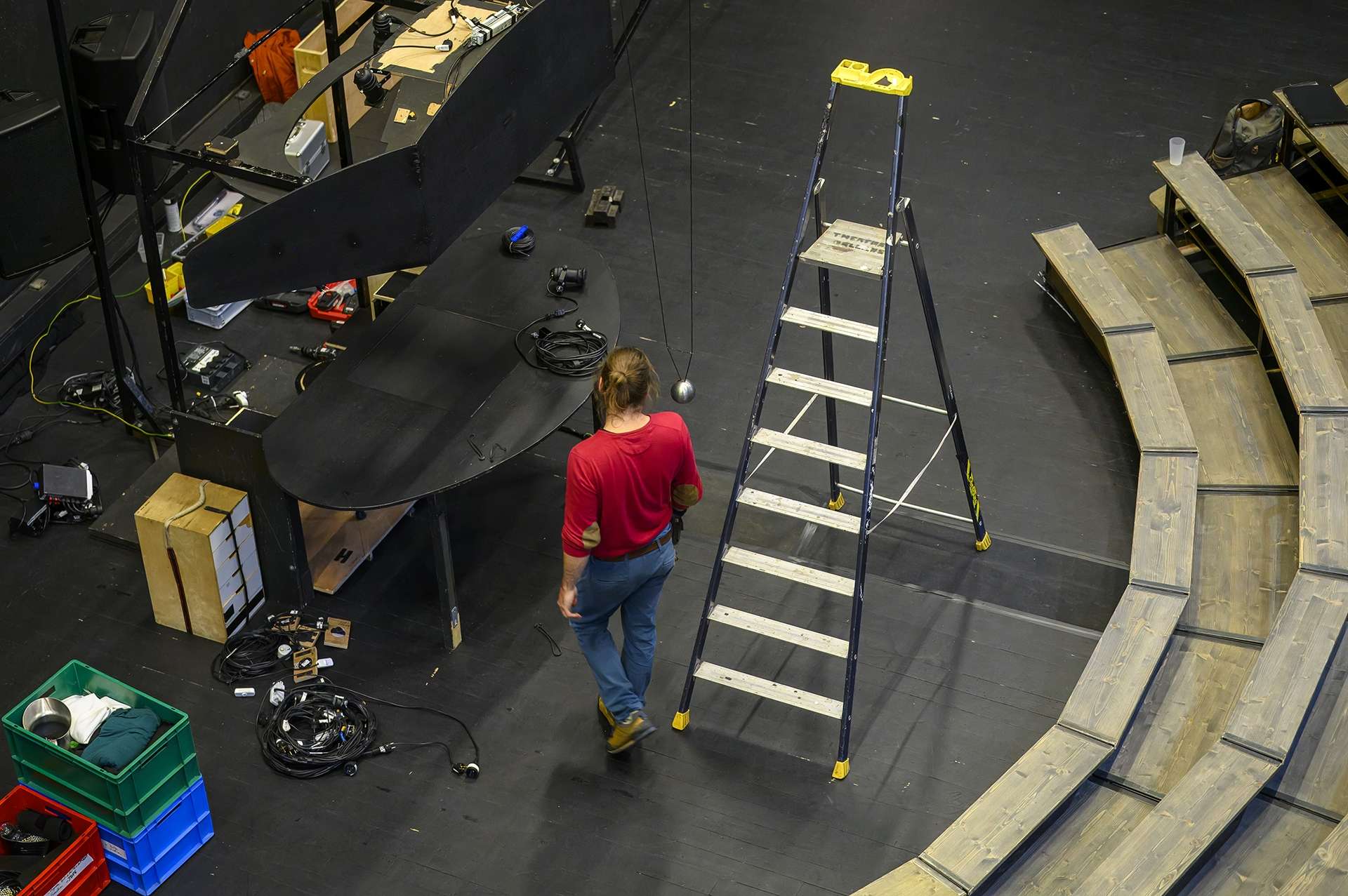 Un technicien est sur le plateau, entouré d'éléments techniques et de décors.