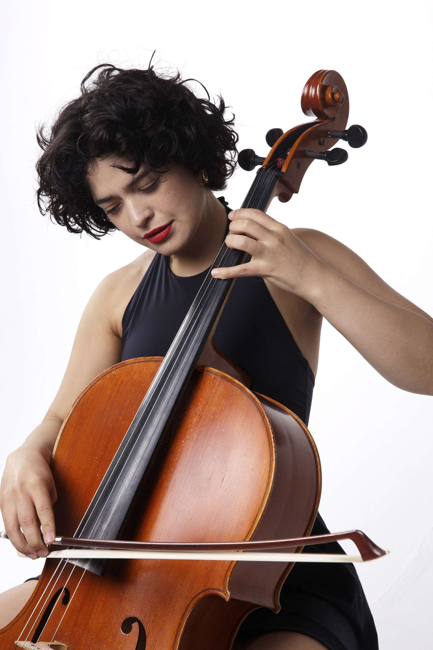 Photo studio. Portrait de trois quart d'Ana Carla Maza jouant du violoncelle. 