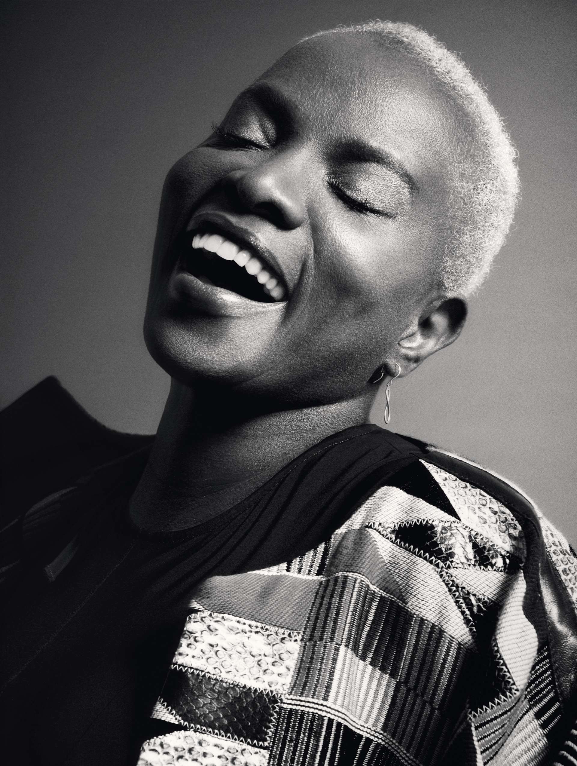 Portrait en noir et blanc de la diva. Les yeux fermés, Angélique Kidjo rayonne grâce à son sourire communicatif. 