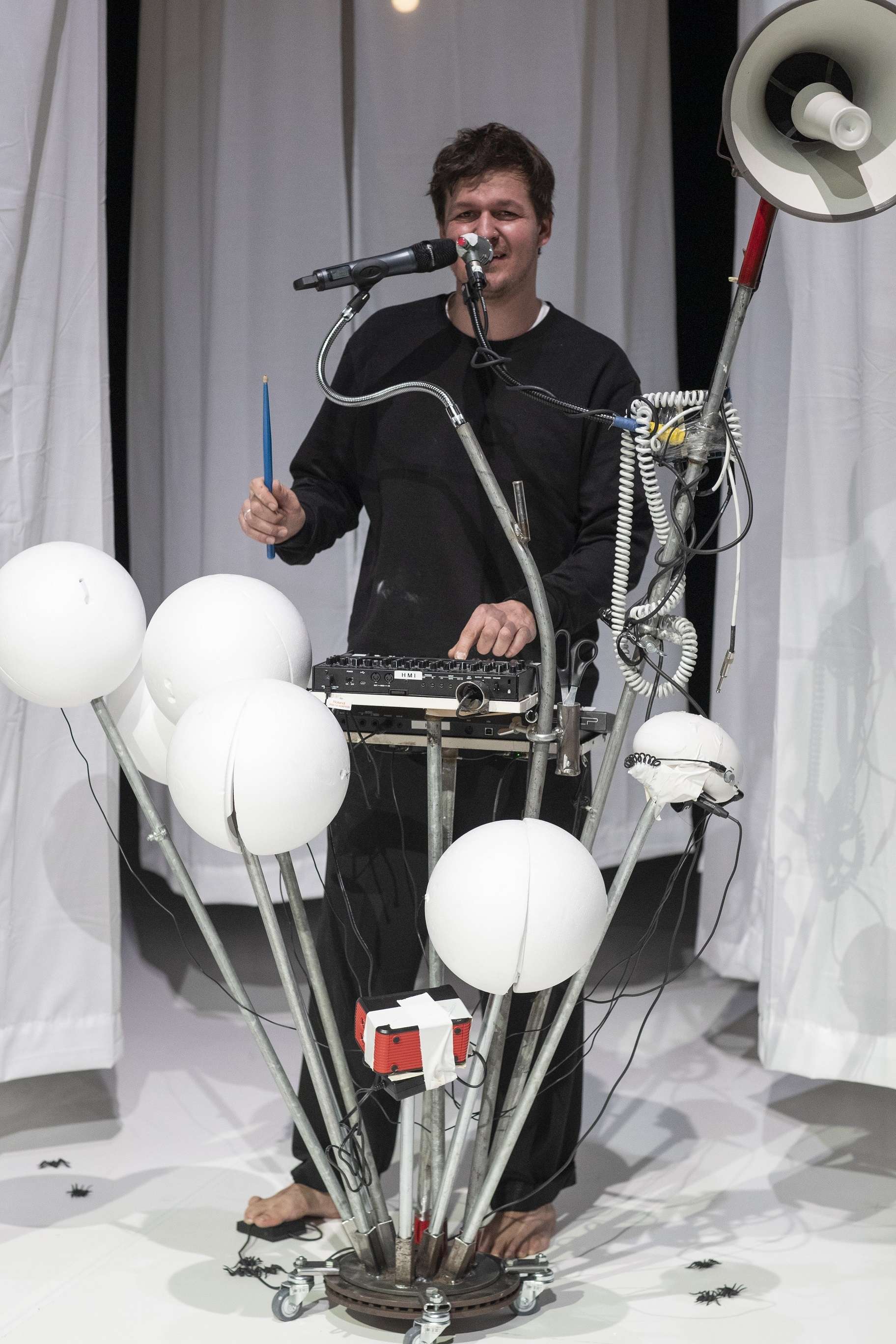 Un musicien joue sur une machine ornée d'une grappe de ballons.