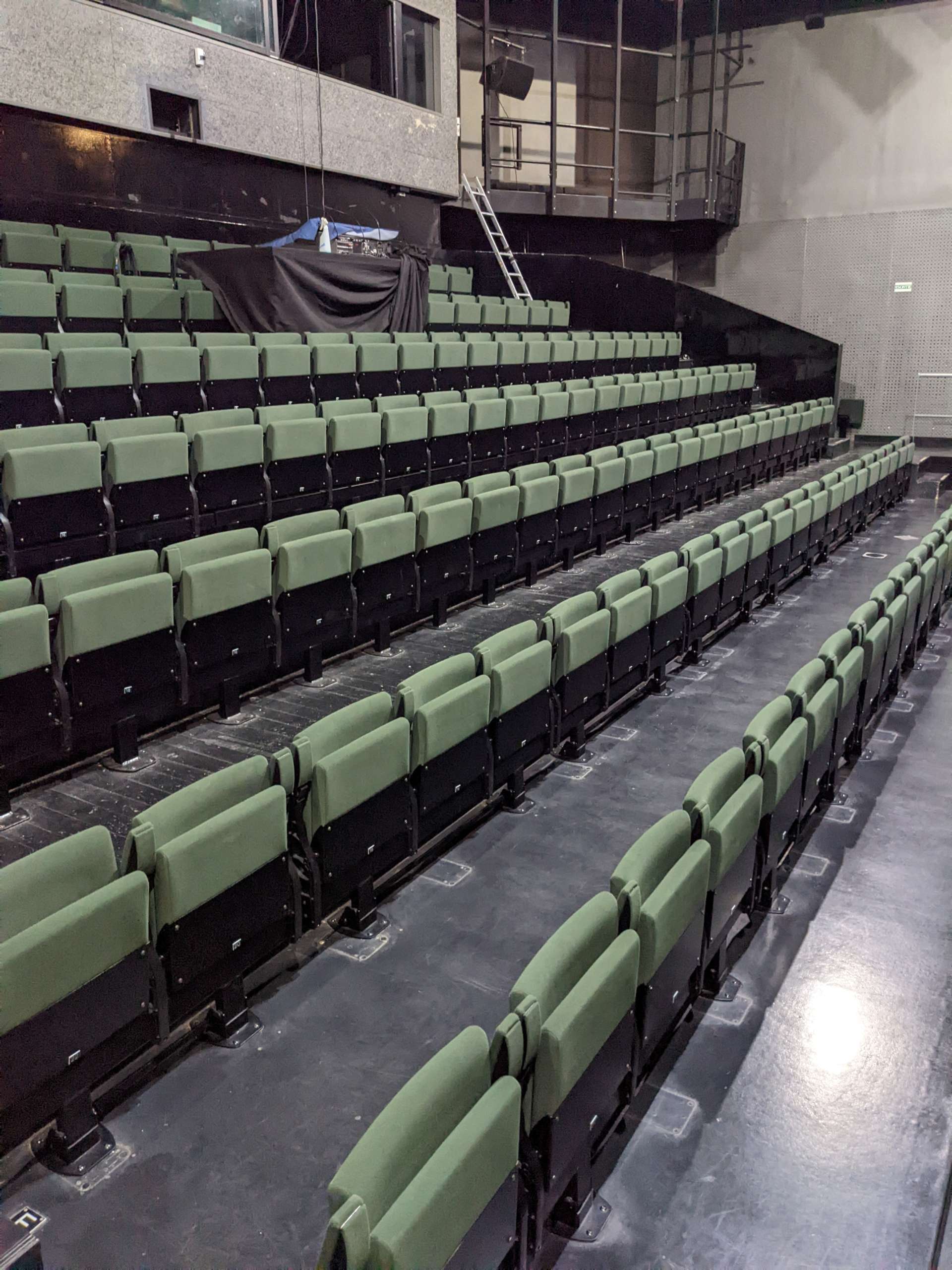 Salle Vitez, vue des fauteuils verts de type strapontins. 