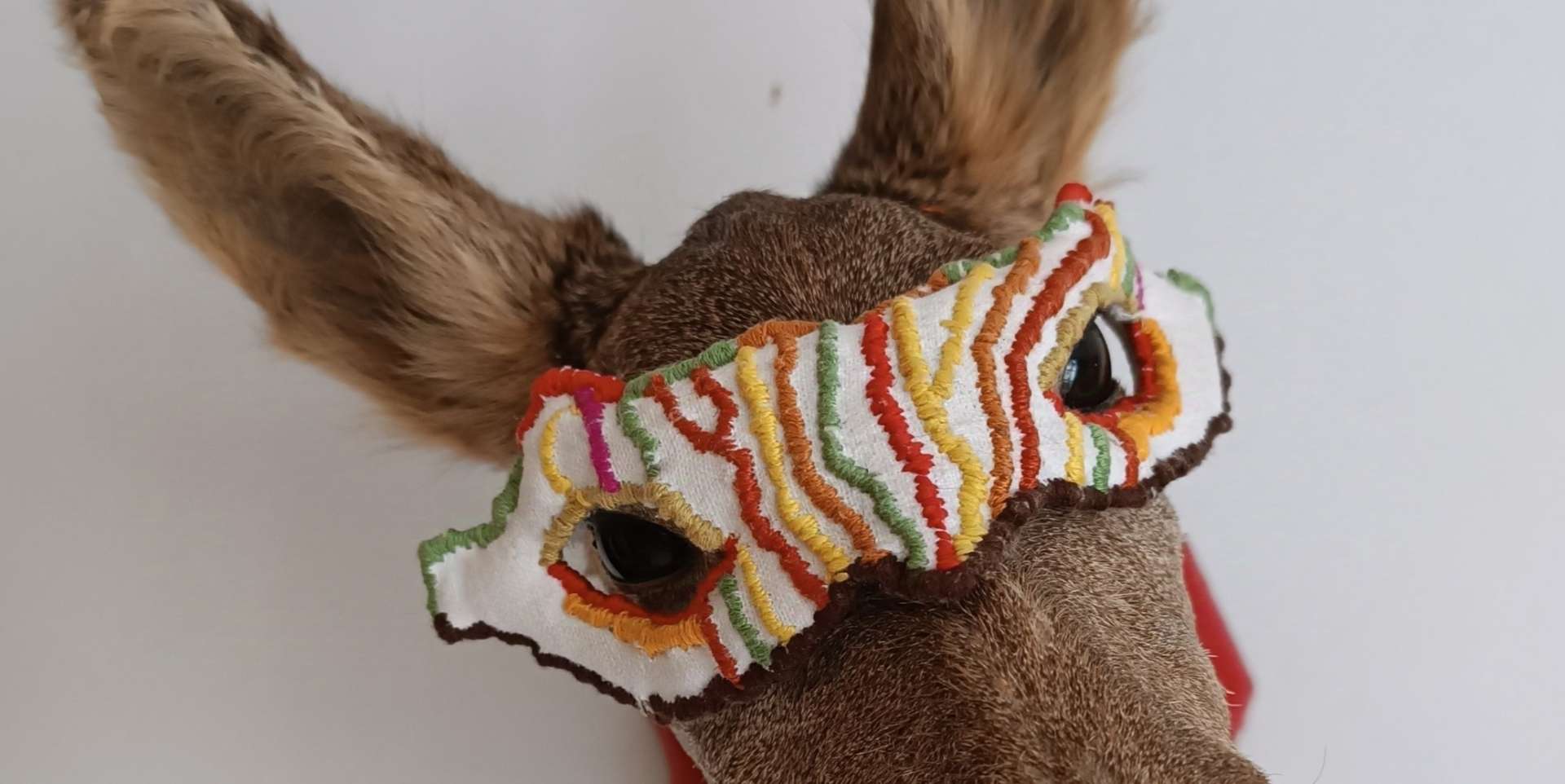 Biche avec un masque tissé de couleurs