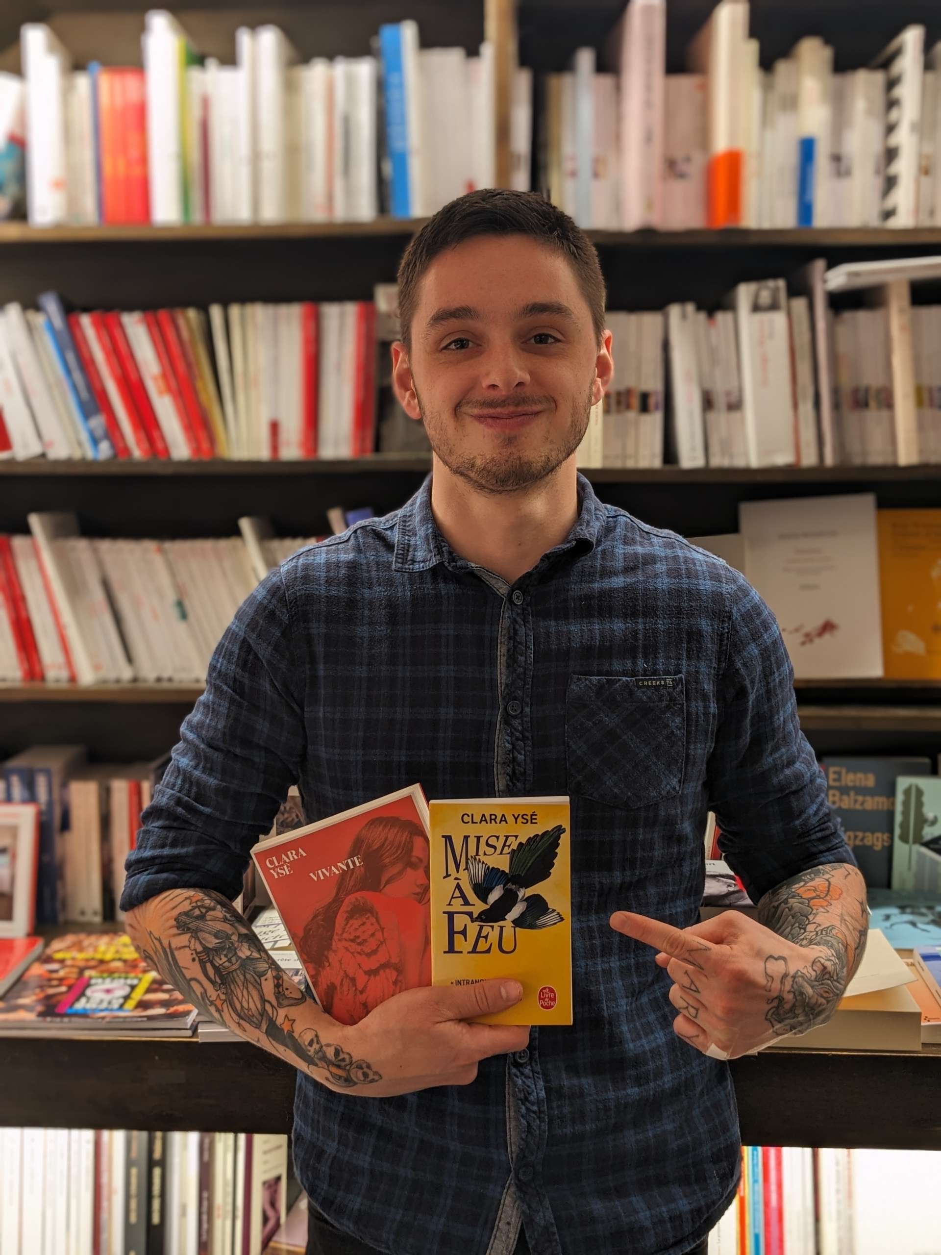 Antoine Vigne, libraire chez Les Temps Modernes à Orléans, tient deux livres de Clara Ysé. 