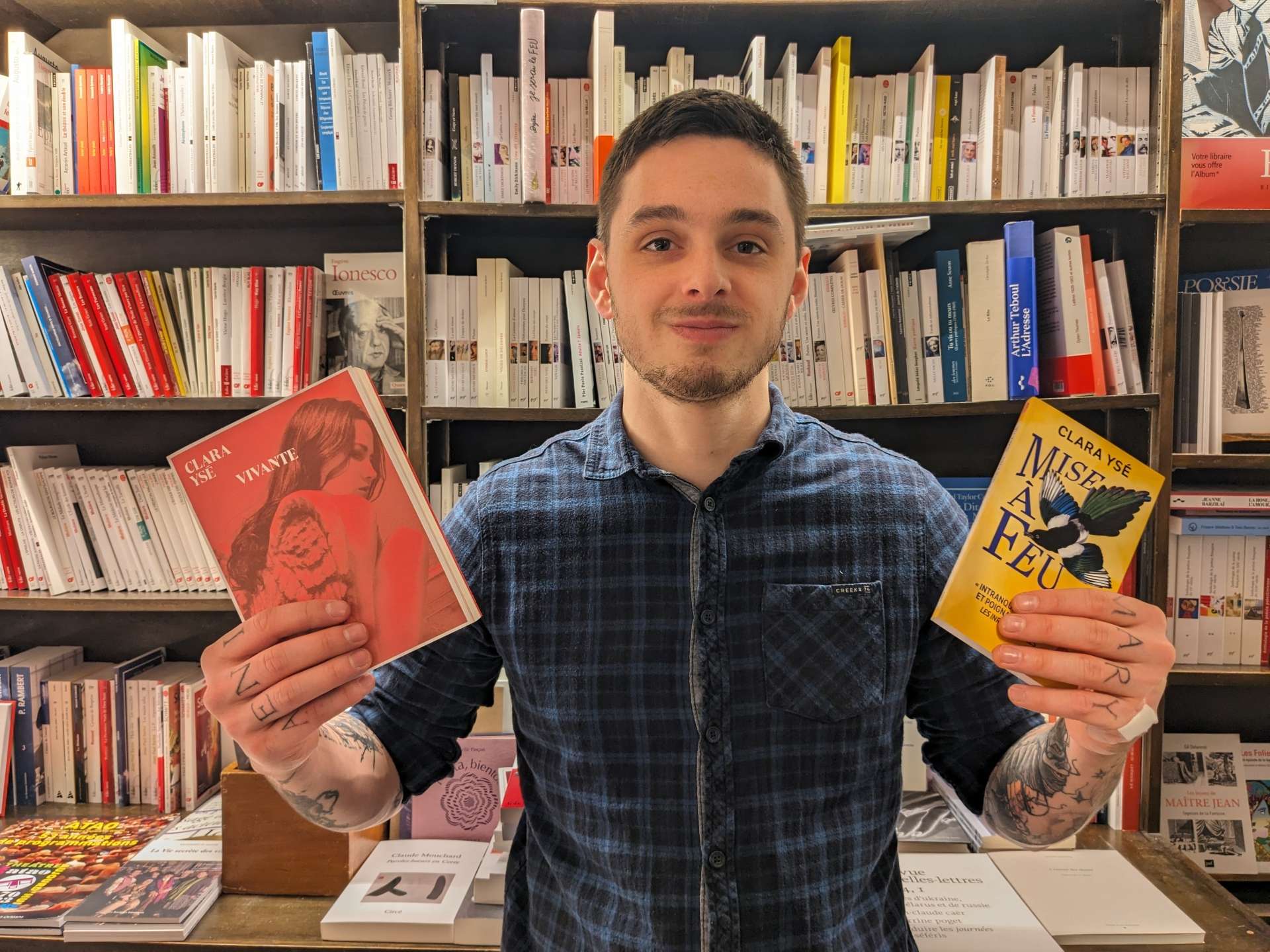 Antoine Vigne, libraire chez Les Temps Modernes à Orléans, tient deux livres de Clara Ysé. 